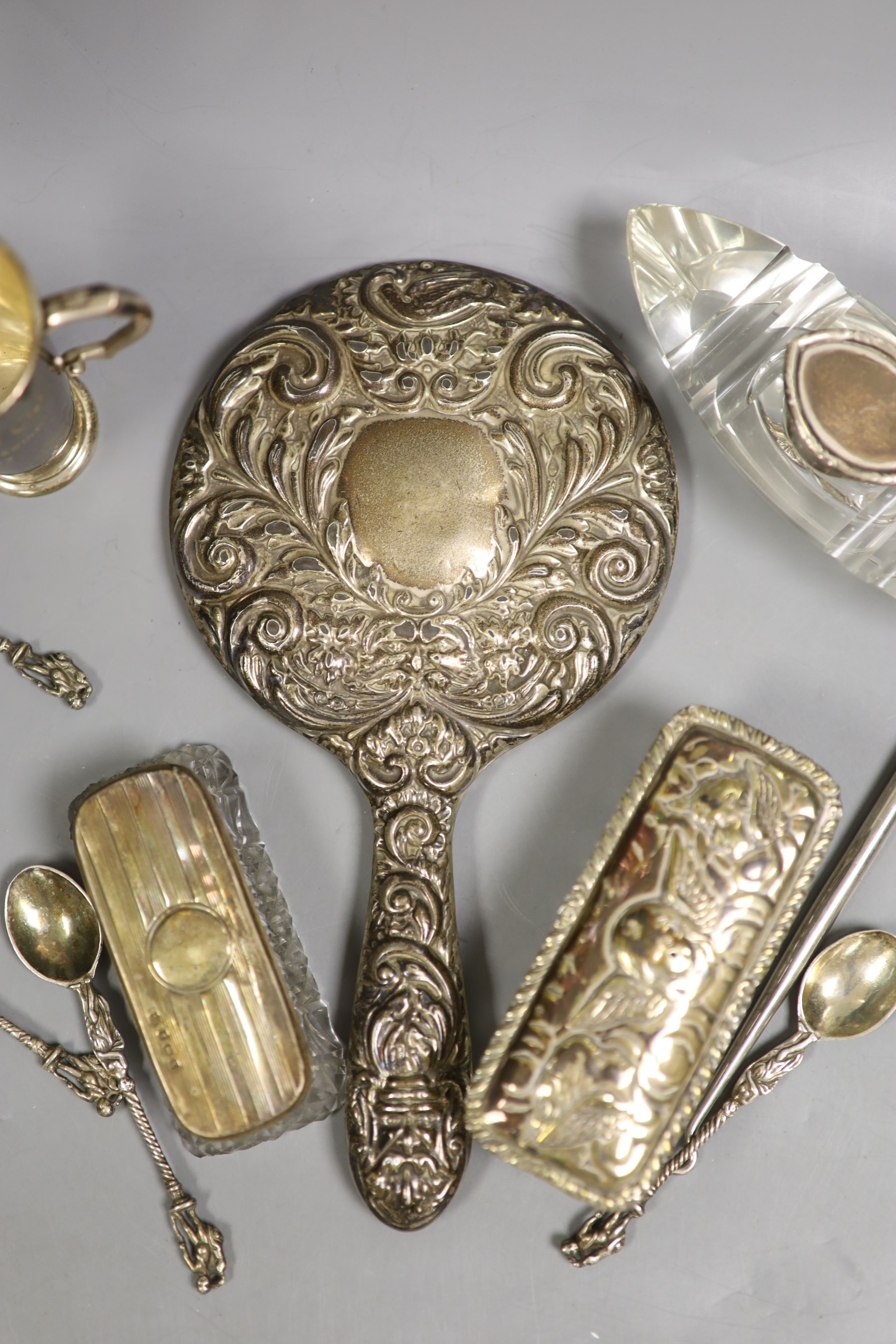 Small silver including a hand mirror, two mounted glass toilet jars, two handled golfing related trophy cup, silver spoons, white metal and enamel dish etc.